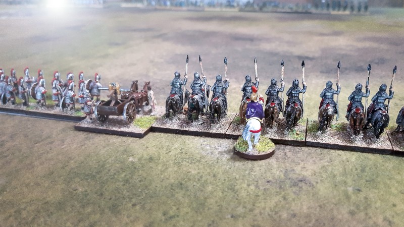 Die römische Streitmacht hat ihre Formation eingenommen und richtet den Blick über das offene Terrain auf den Feind. Links stehen die Legionäre, unterstützt von einer mobilen sog. Carroballista, daneben die schwergepanzerten Catafractarii. An ihrer Seite führt der General das Kommando. Es freut mich, meine spätrömische Armee jetzt auch mit &quot;Age of Hannibal&quot; spielen zu können.